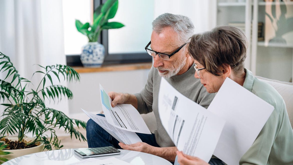 Elderly couple checking documents with tax and internal bills